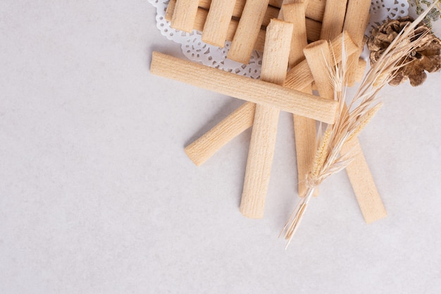 Koekjesstokken met dennenappel op witte ondergrond