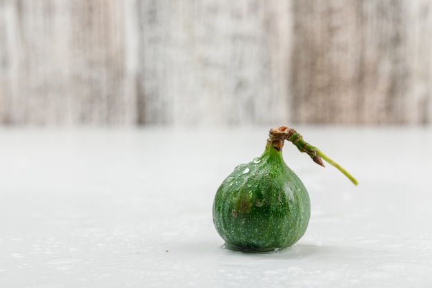 Gratis foto koel fig. zijaanzicht over witte en grungy houten muur