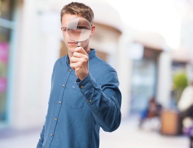 Gratis foto koele jonge man met een vergrootglas