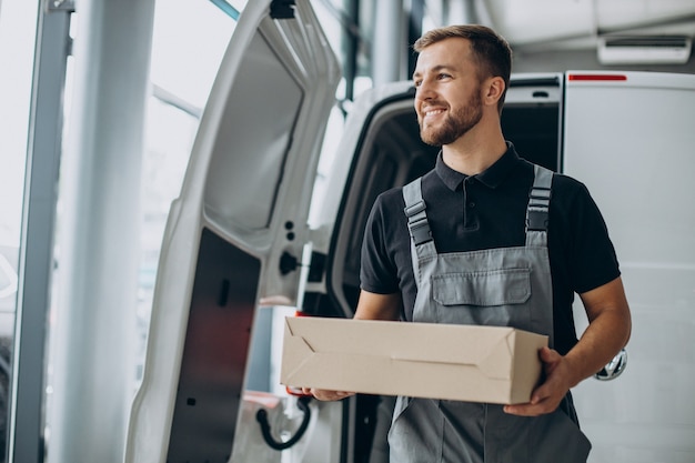 Koerier met levering kartonnen doos bij de auto