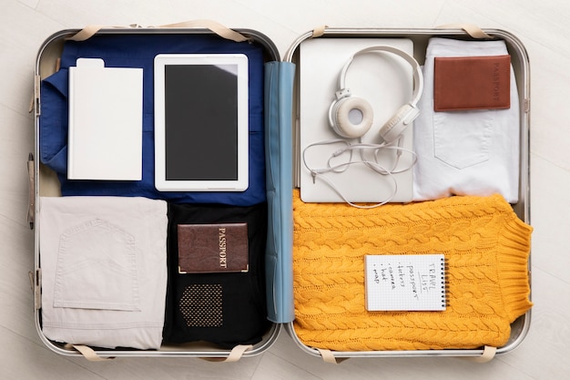 Koffer met koptelefoon en paspoort voor op reis