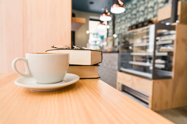 Koffie, dagboek en bril op houten bureau