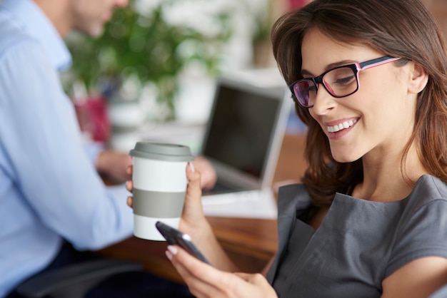 Gratis foto koffie drinken en mobiele telefoon gebruiken