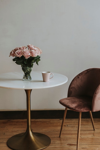 Koffie in een roze kopje bij een vaas met roze rozen