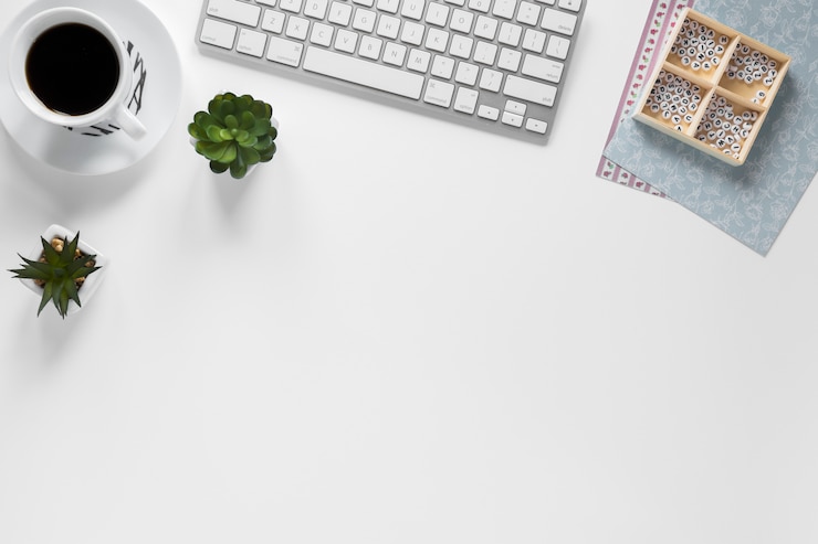 Gratis Foto koffiekop; toetsenbord; cactusplant en doos met kaartdocumenten op werkplaats