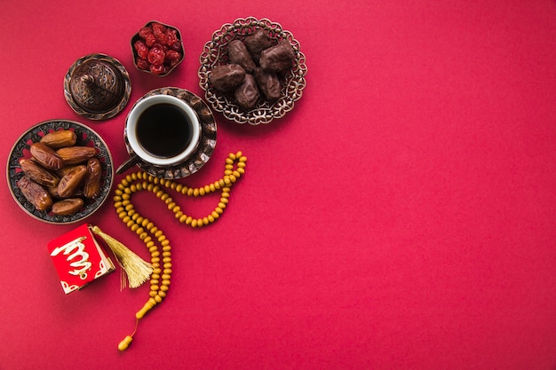 Gratis foto koffiekopje met dadels fruit en kralen