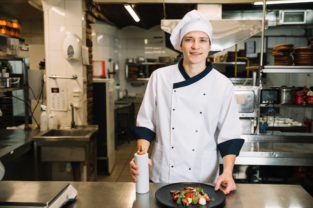 Gratis foto kok die zich met sausfles en salade bevindt