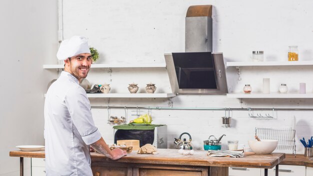 Kok in de keuken die deeg maakt.