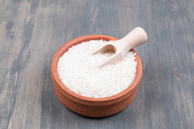Gratis foto kom gekookte rijst met lepel op houten tafel