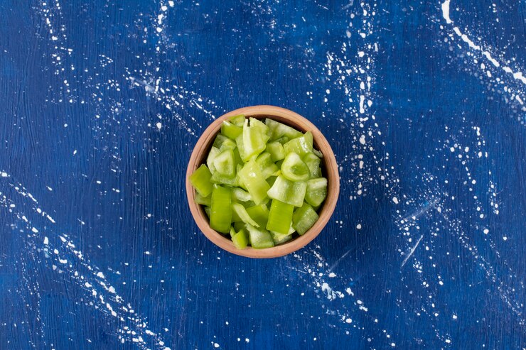 Gratis Foto kom gesneden groene paprika op marmeren oppervlak