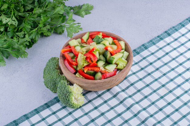 Kom groentesalade, bundel peterselie en broccoli op marmeren achtergrond. Hoge kwaliteit foto