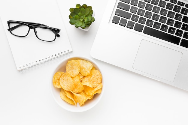 Gratis foto kom met chips op bureau