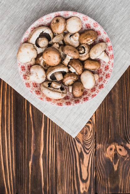 Gratis foto kom met paddestoelen die zich op servet bevinden