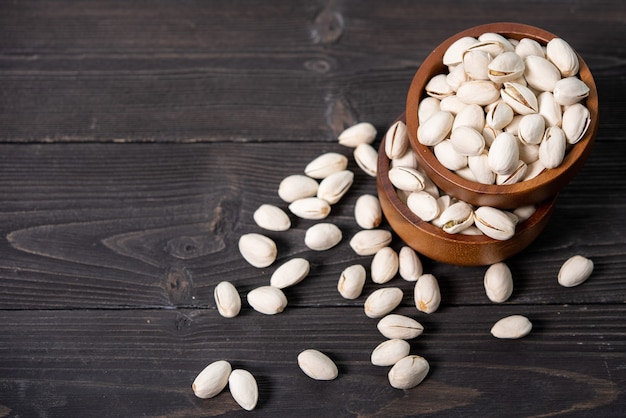 Kom met pistachenoten op een houten tafel.