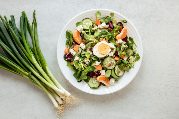 Gratis foto kom met salade en groene ui naast