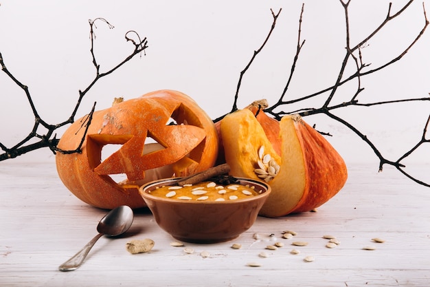 Kom met soep staat voor scarry halloween pompoen op de tafel