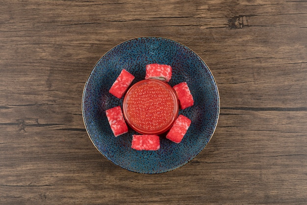 Kom sushibroodjes en rode kaviaar op houten tafel