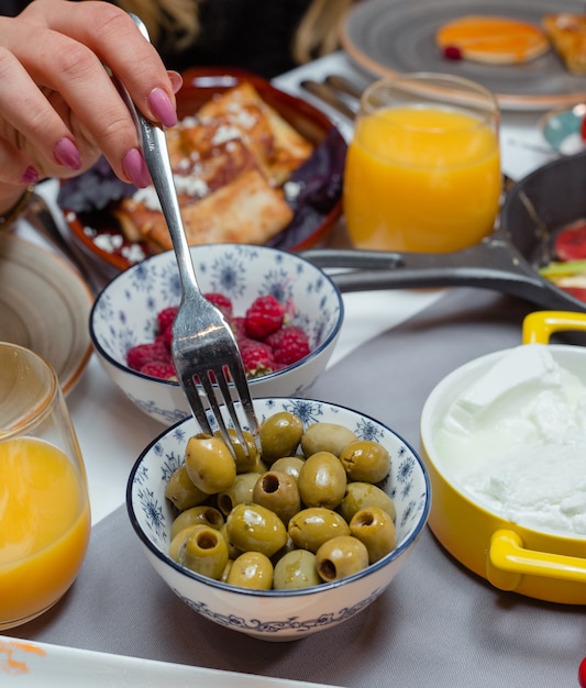 kommen met olijf- en frambozensap en pannenkoeken