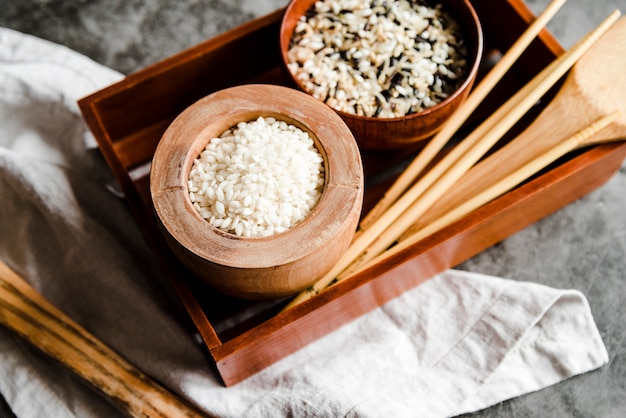 Kommen met verschillende rijst en houten eetstokjes
