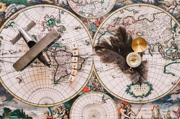 Kompas en veren in de buurt van reizen schrijven en vliegtuig