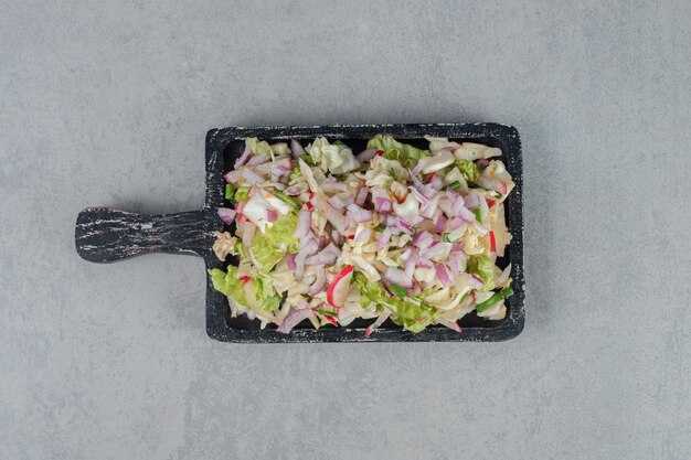 Kool en sla salade op een houten bord.