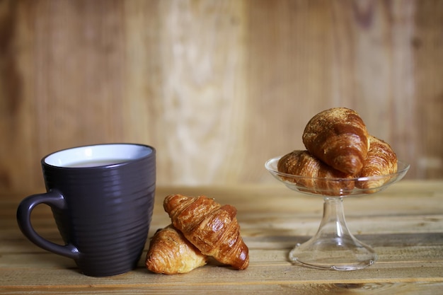 Kop croissant ontbijt houten achtergrond