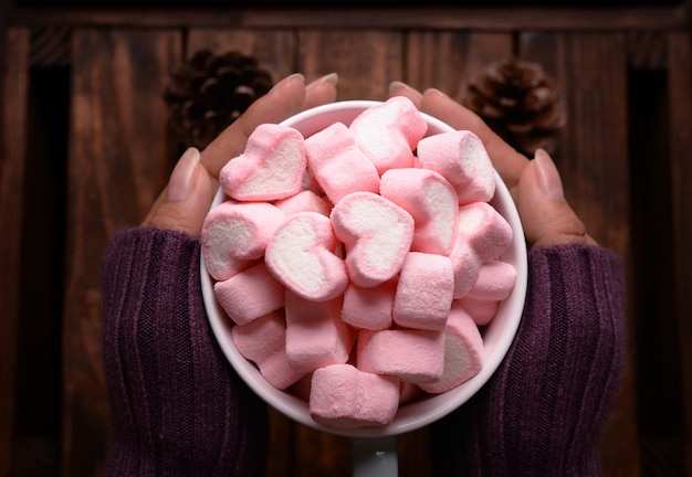 Gratis foto kop snoep marshmallows bij de hand