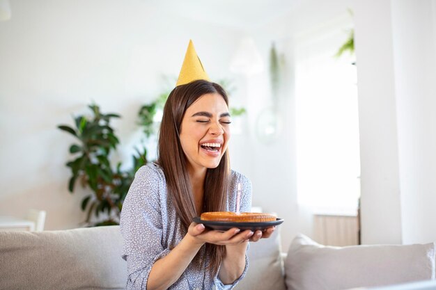 Kopieer een ruimteopname van een vrolijke jonge vrouw die een verjaardagsfeestje heeft met een vriend tijdens een videogesprek Ze maakt een feestelijke toast met een glas witte wijn naar een laptopcamera