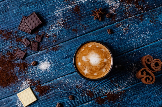 Kopje cappuccino en kaneel met chocolade met latte art of universe