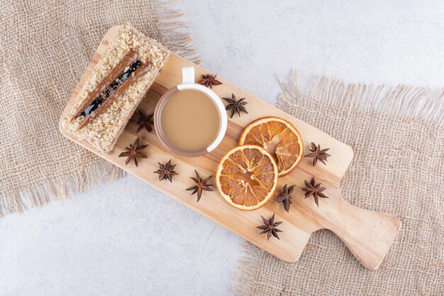Kopje koffie, cake en stukjes sinaasappel op een houten bord. Hoge kwaliteit foto