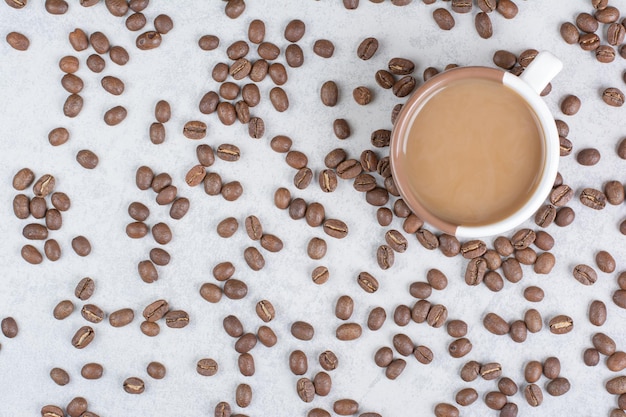 Kopje koffie en koffiebonen op marmeren achtergrond. Hoge kwaliteit foto