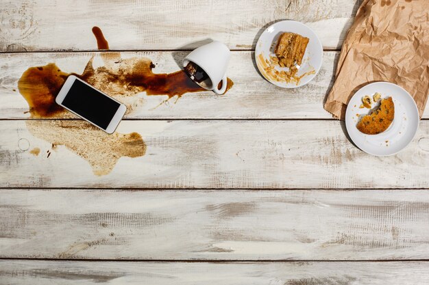 Kopje koffie gemorst op houten tafel