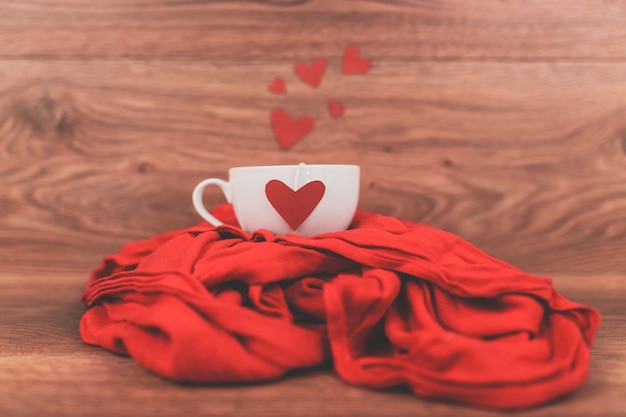 Gratis foto kopje koffie met een rood hart op een sjaal