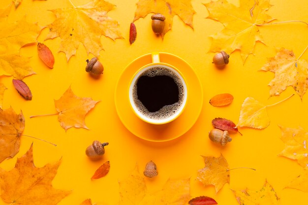 Kopje koffie met herfstbladeren