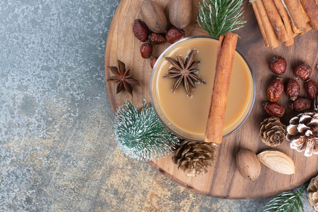 Kopje koffie met pijpjes kaneel en pinecones op houten plaat. hoge kwaliteit foto