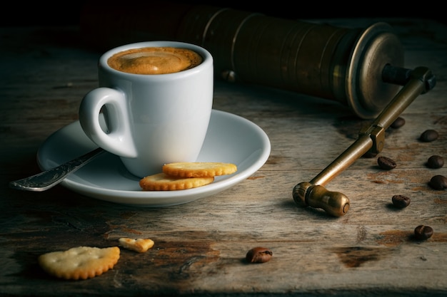 Kopje koffie met Vintage Grinder, Cookie en koffiebonen. Turkse koffie op oude houten tafel.