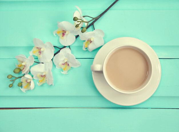 Kopje koffie op oud houten tafelblad met verse lentebloemen