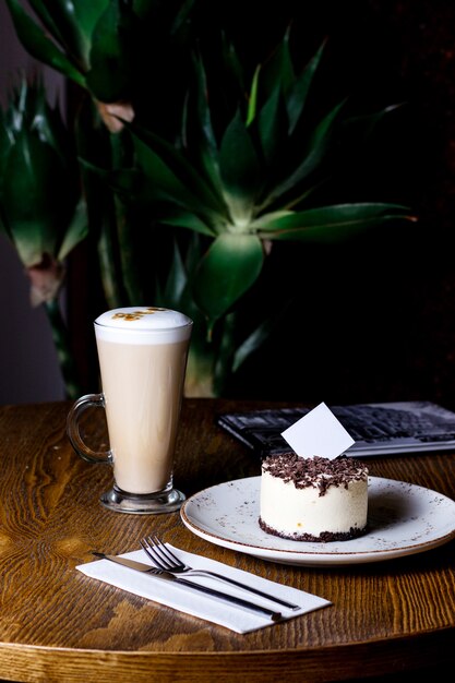 Kopje latte met chocolade bestrooid cheesecake