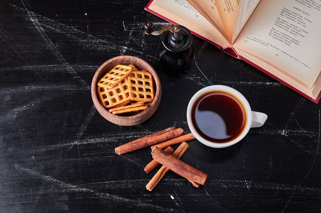 Kopjes koffie met crackers en kaneel.