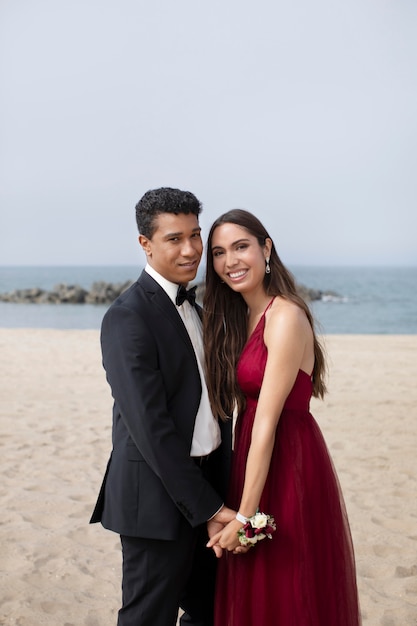 Koppel in afstudeerbalkleding op het strand