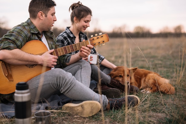 Gratis foto koppel met gitaar en huisdier