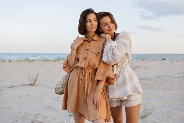 Koppel met korte kapsel in linnen zomer kleding poseren op het strand