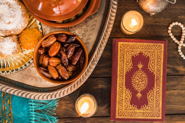 Koran en kaarsen dichtbij Arabisch voedsel