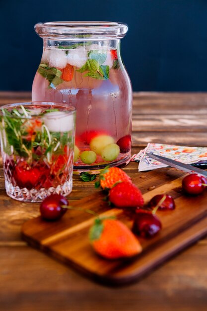 Koud, verfrissend drankje met aardbeien en munt in pot