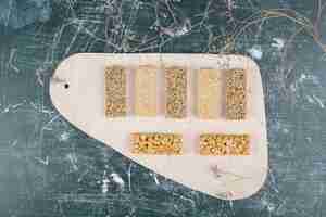 Gratis foto kozinaki-snoepjes met zaden en noten op een houten bord. hoge kwaliteit foto