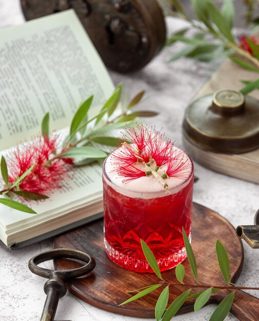 kristalglas van rode cocktail gegarneerd met bloem