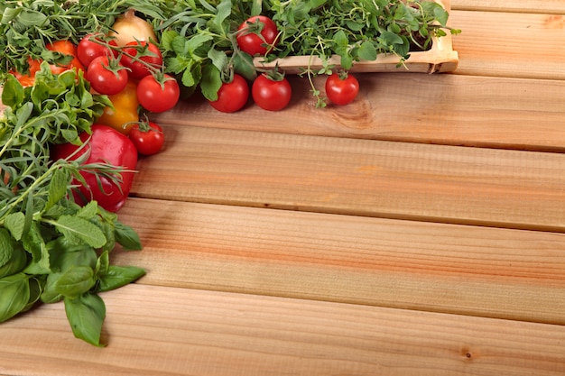 Kruiden en groenten met een houten plank