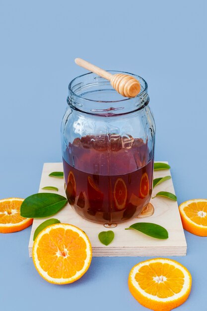 Kruik met eigengemaakte honing en sinaasappelen