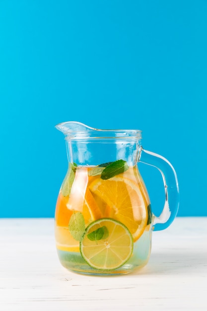 Kruik met zelfgemaakte limonade met blauwe achtergrond