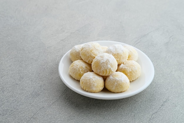 Kue putri salju of sneeuwwitje koekjes gemaakt van bloemsuiker en boter omhuld met poedersuiker Premium Foto